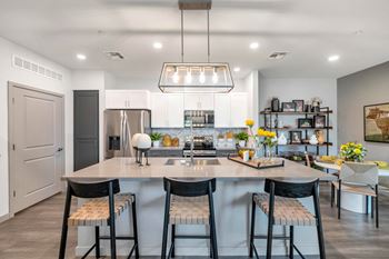a kitchen with a large island with four stools at Weylyn Luxury Apartments, Laveen, Arizona